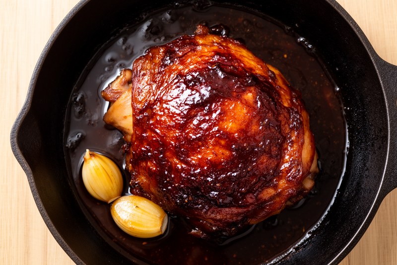 Adobo sauce reduced to thick glossy dark glaze coating the chicken thighs