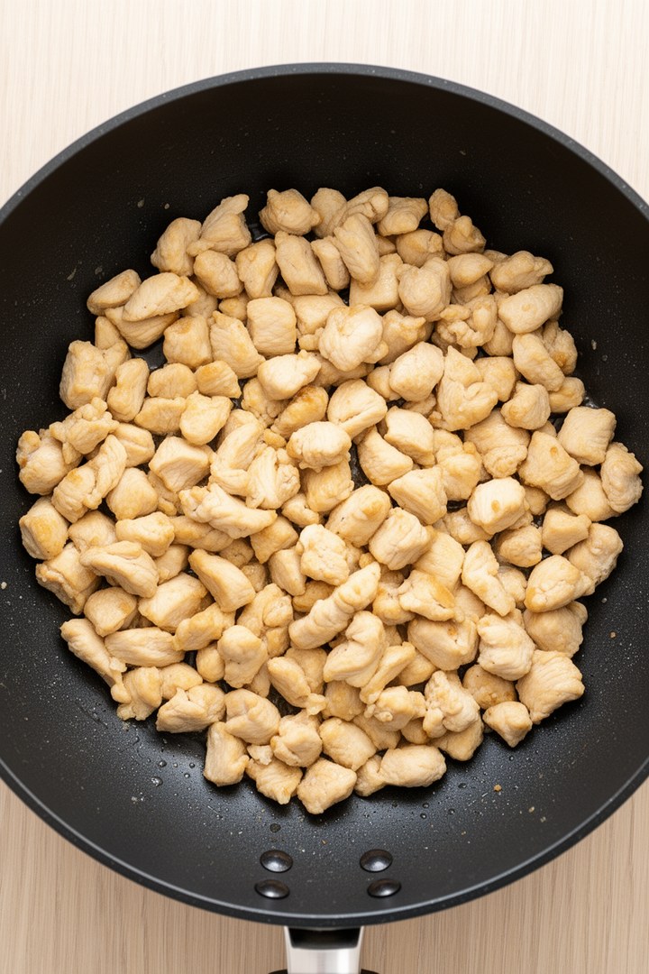 Step 2 of making Kung Pao Chicken — Sear chicken in wok