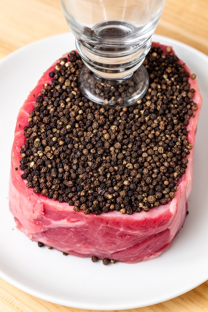 Step 1 of making Steak Au Poivre Recipe — Crust peppercorns onto steak
